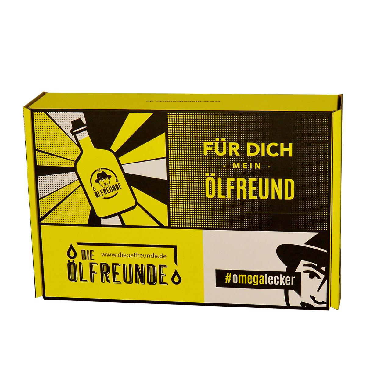 Geschenkebox in gelber Farbe. Enthält verschiedene Grafiken und Texte darunter das Logo der Ölfreunde, der Aufschrift 'Für dich mein Ölfreund', die Webseite der Ölfreunde und den Hashtag #omegalecker.