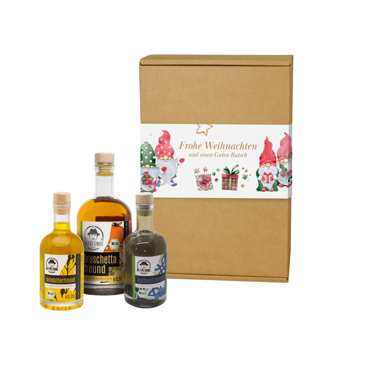 Eine Flasche Leindotteröl, Leindotteröl mit Gewürzen und Bruschetta-Öl, der Marke Die Ölfreunde, vor einer Weihnachts-Geschenkeverpackung.