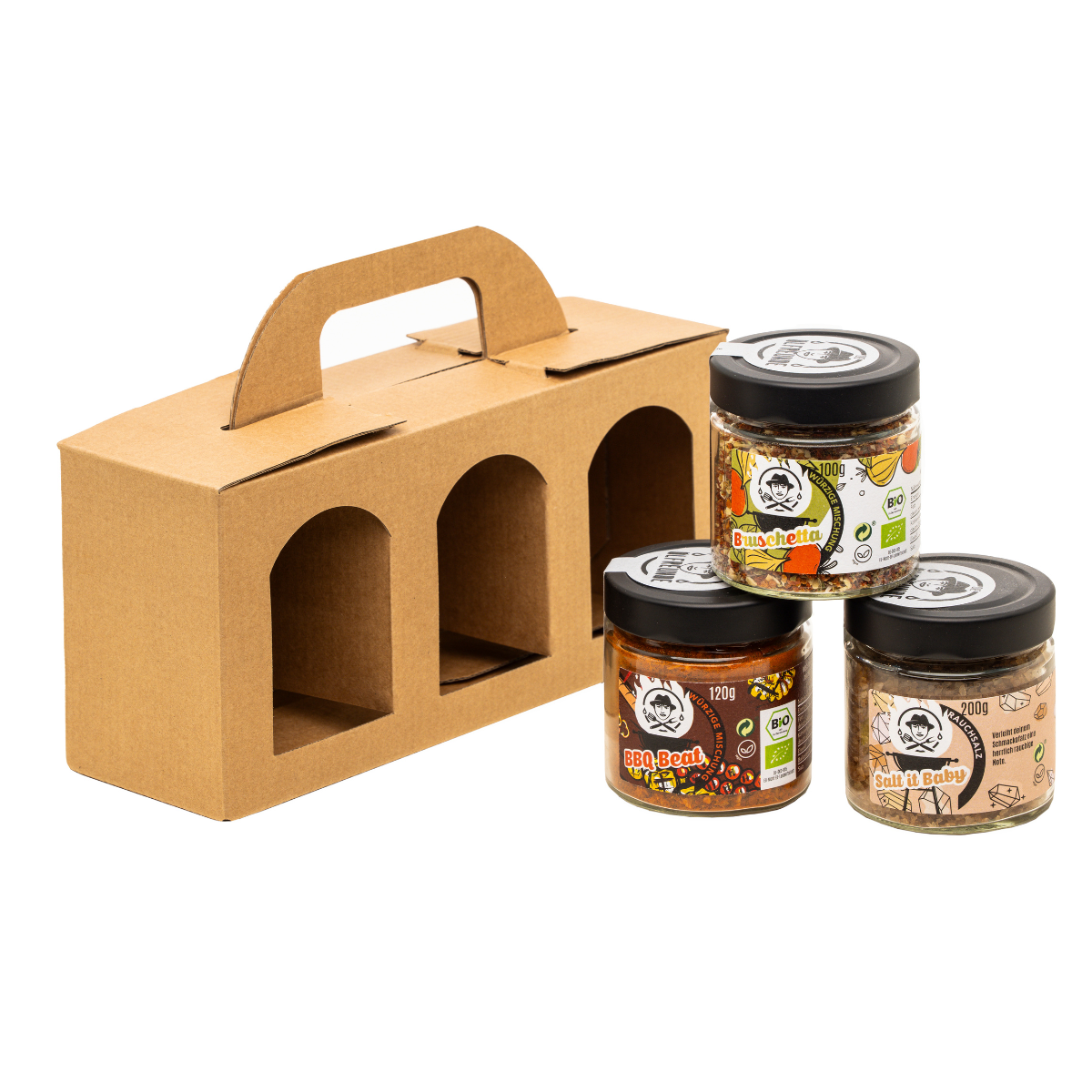 Je ein Glas BBQ-Gewürzmischung, Bruschetta-Gewürzmischung und Rauchsalz der Marke Die Ölfreunde, vor einer Geschenkeverpackung