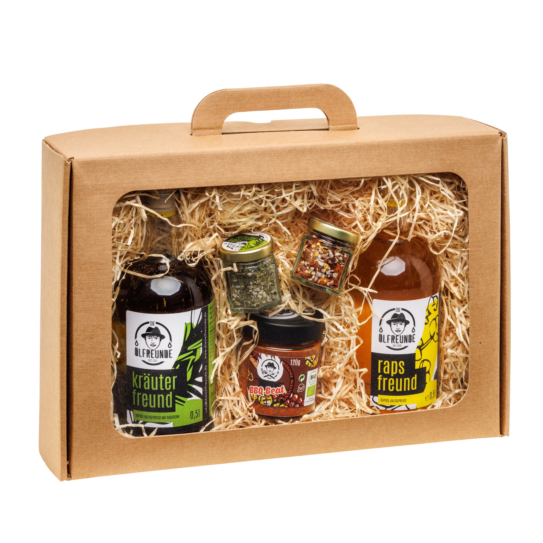 Eine Flasche Kräuteröl, Rapsöl, ein Glas Kräutersalz, Chillisalz und BBQ-Gewürzmischung, der Marke Die Ölfreunde, in einer Geschenkeverpackung.