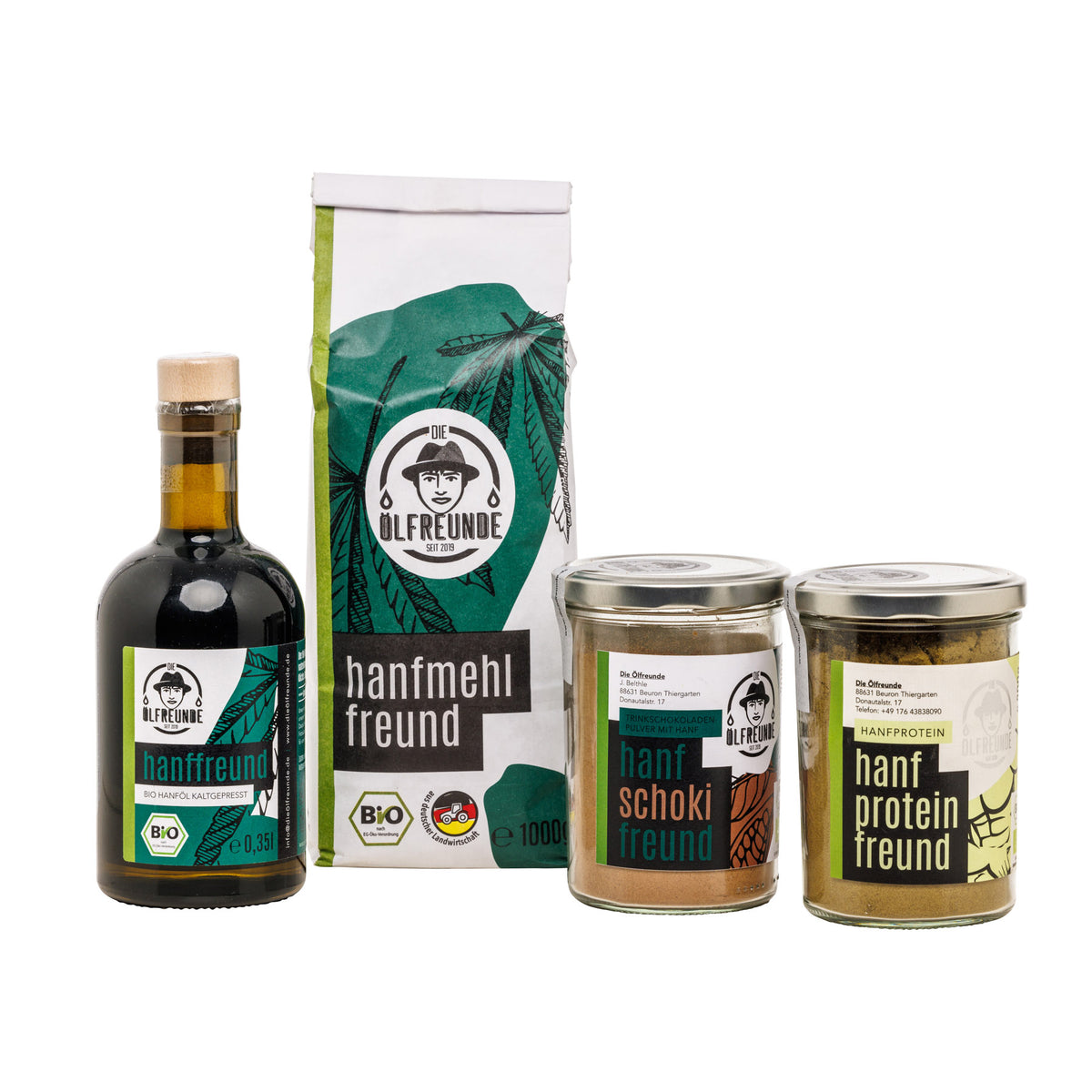 Ein Glas Trinkschokolade mit Hanf, ein Glas Hanfprotein, eine Flasche Hanföl und eine Tüte Hanfmehl der Marke Die Ölfreunde.