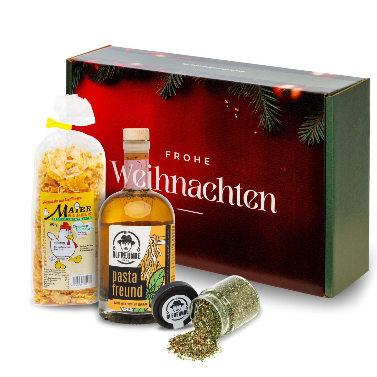 Eine Packung Drachenhörnchen-Nudeln der Marke Maier Nudeln, eine Flasche Pasta-Öl und ein Glas mit einer Gewürzmischung der Marke Die Ölfreunde, vor einer Weihnachts-Geschenkverpackung.