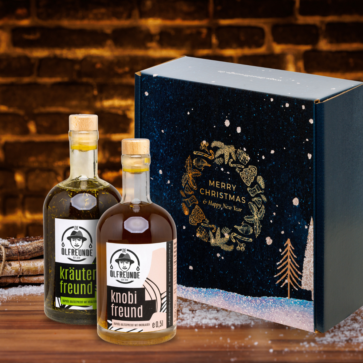 Eine Flasche Kräuteröl und Knoblauchöl der Marke Die Ölfreunde vor einer Weihnachts-Geschenkverpackung und einem dunklen Hintergrund, neben einem Bündel Holz.