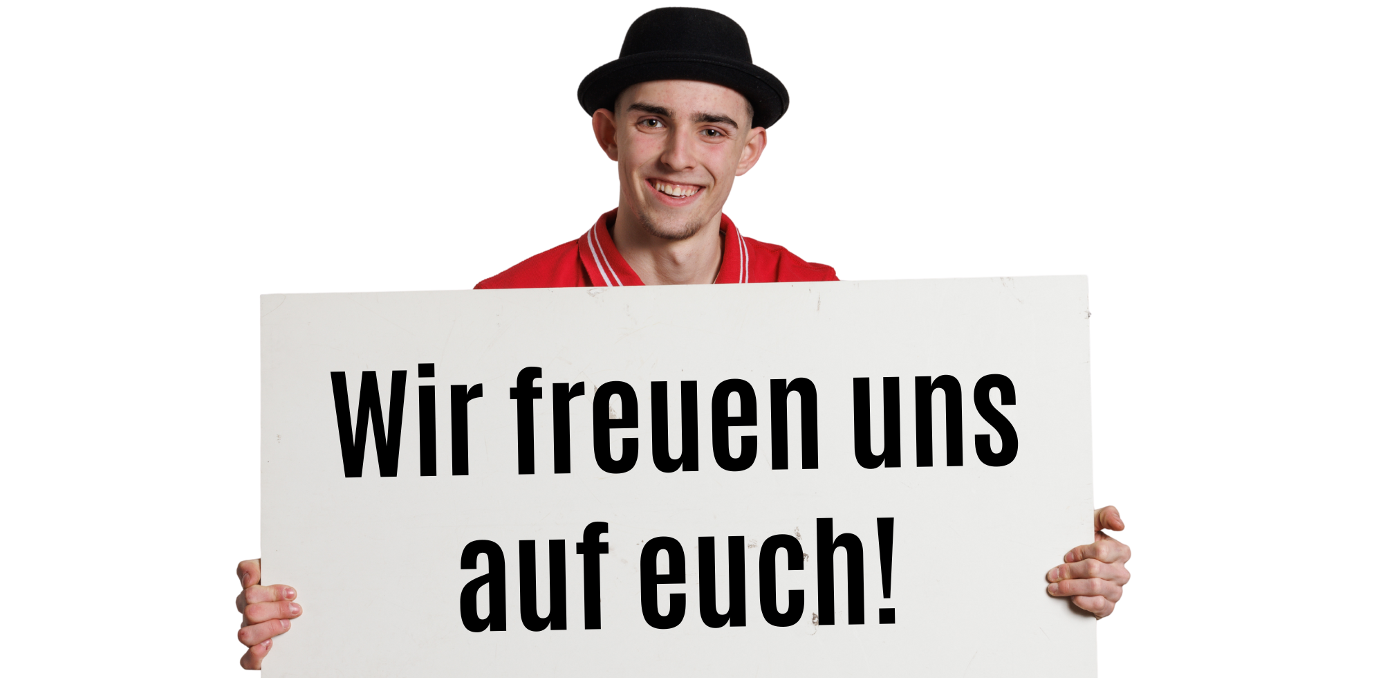 Person mit schwarzem Hut und rotem Shirt hält ein weißes Schild mit der Aufschrift ‚Wir freuen uns auf euch!‘ vor sich.