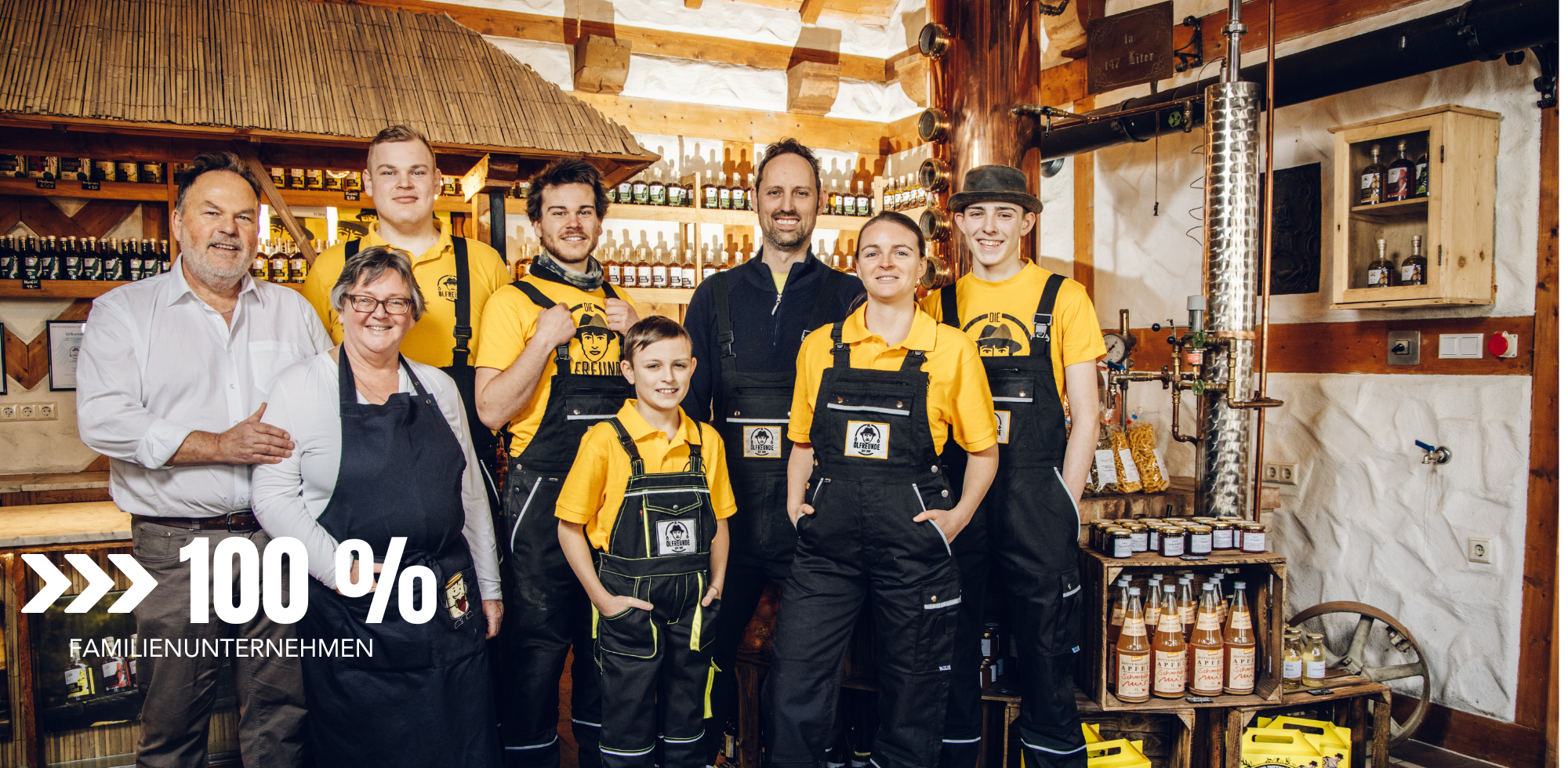 Ein Familienunternehmen in einem rustikalen Gebäude – das Team steht vor einer Holztheke, umgeben von einem vielfältigen Sortiment an Produkten.