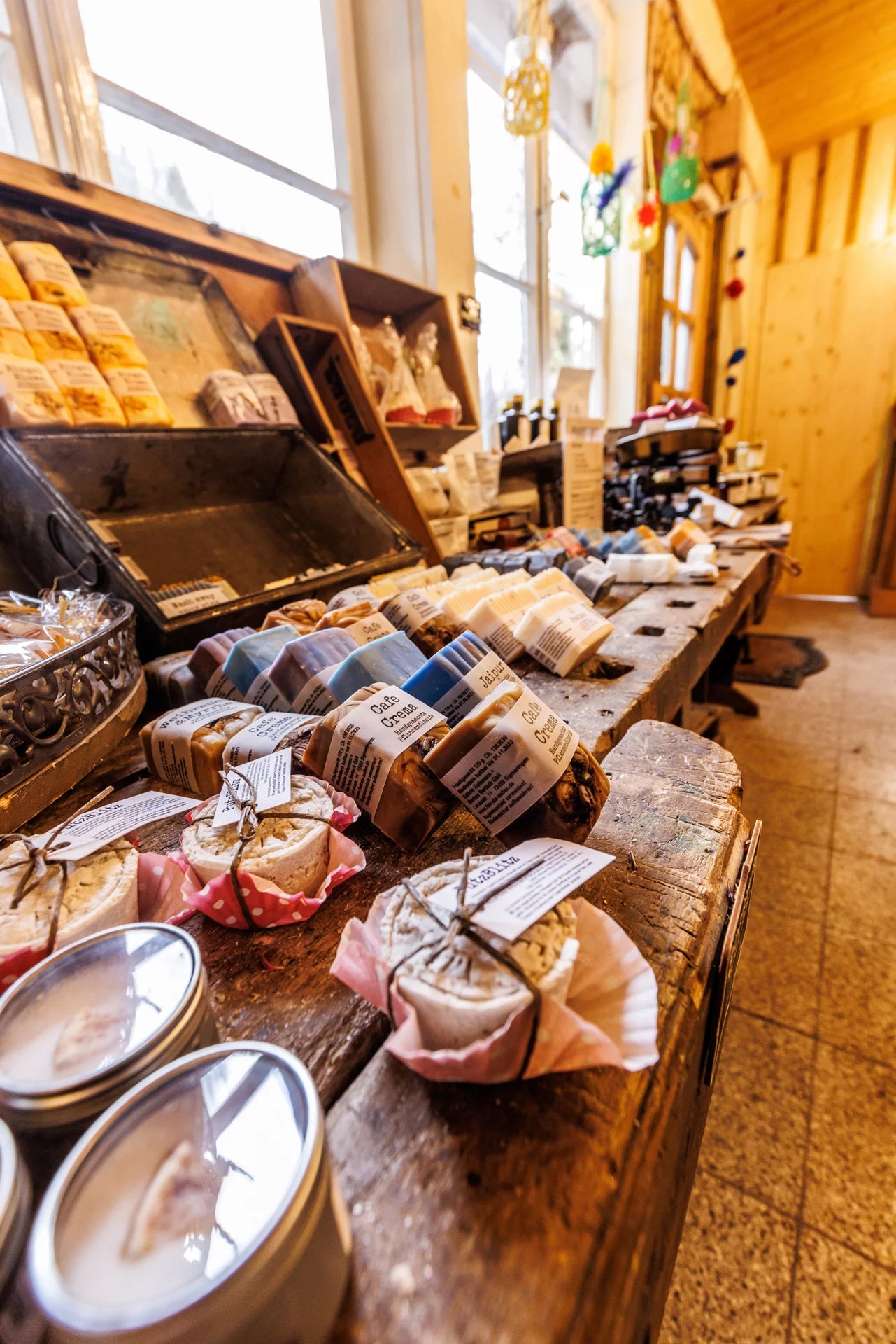 Das Innere eines Ladens. Üppige, hölzerne Regale sind gefüllt mit Handgemachter Seife.