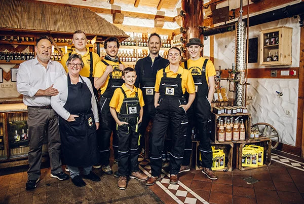 Ein Familienunternehmen in einem rustikalen Gebäude – das Team steht vor einer Holztheke, umgeben von einem vielfältigen Sortiment an Produkten.