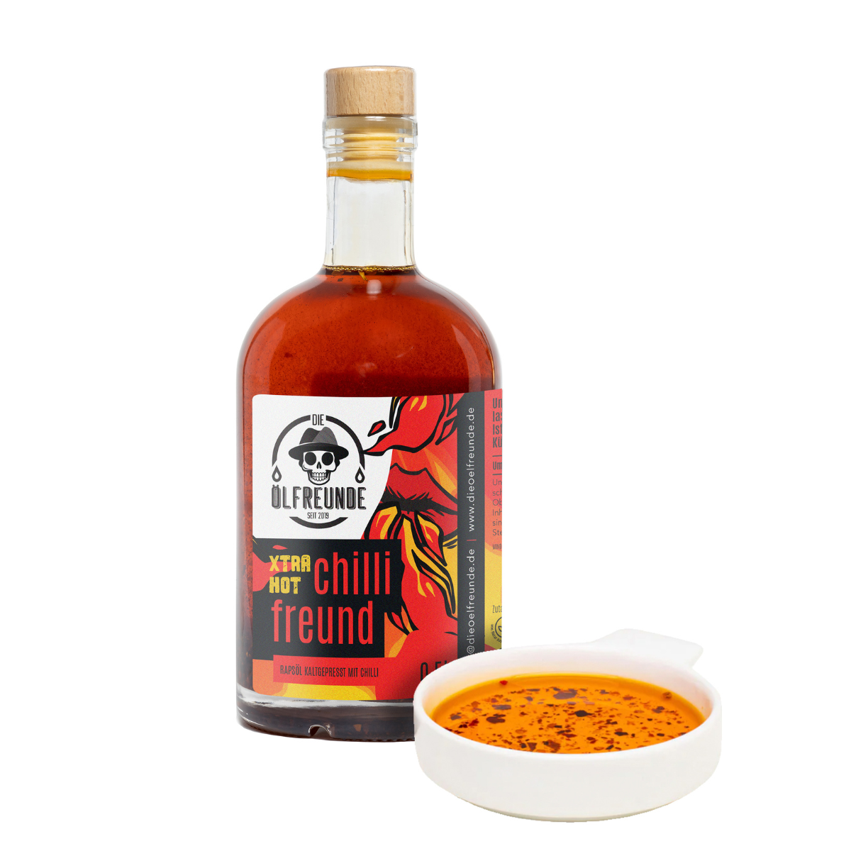 500-ml-Flasche kaltgepresstes Chilli Öl extra hot, mit crispy Chillistückchen von Marke Die Ölfreunde, daneben eine Schale mit Chilli Öl.